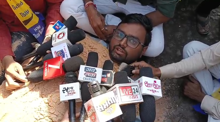 ધોરાજીમાં જૂનાગઢ રોડ ઓવરબ્રિજ મુદ્દે ‘આપ’નો અનોખો હલ્લાબોલ: રસ્તા પર ‘સમાધિ’ સાથે ચક્કાજામ, પોલીસ કાર્યવાહીથી પરિસ્થિતિ તંગ.